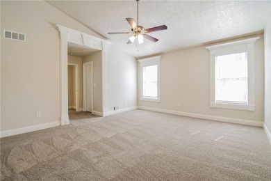 Unfurnished room featuring visible vents, lofted c