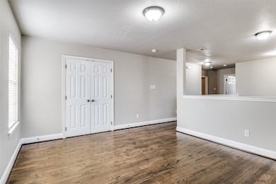 Unfurnished room with wood finished floors and baseboards
