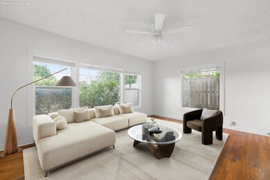 Living room with wood finished floors, a textured