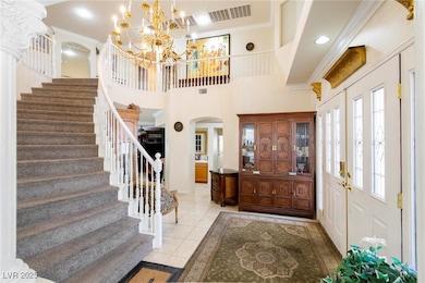 Tiled foyer featuring a notable chandelier, orname