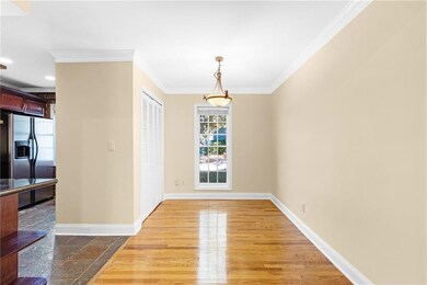 Unfurnished dining area featuring ornamental molding and dark wood-type flooring