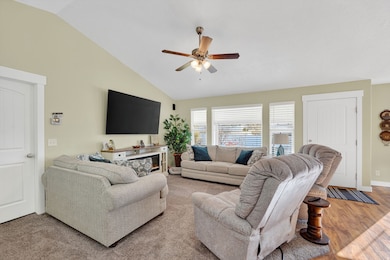 Living area with vaulted ceiling and a ceiling fan