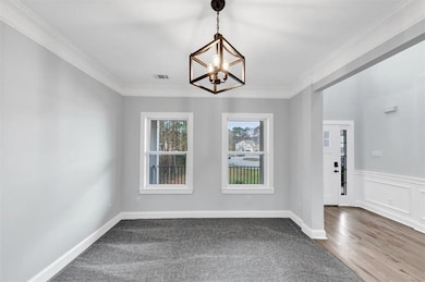 Empty room featuring visible vents, crown molding,