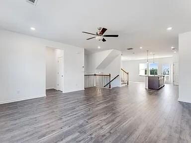 Unfurnished living room with dark wood-type flooring, recessed lighting, and ceiling fan