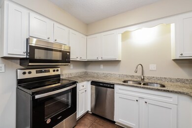 Kitchen with white cabinetry, sink, and stainless 