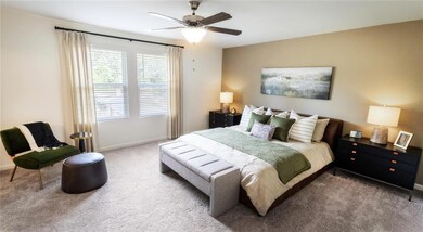 Carpeted bedroom featuring ceiling fan