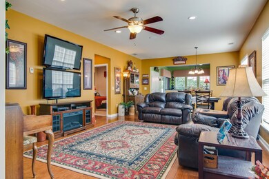 Spacious living room with speaker, recessed lighting, and ceiling fan. 