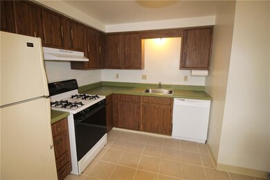 Ceramic tile eat in kitchen with new dishwasher.