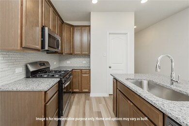 Kitchen with appliances with stainless steel finishes, light stone countertops, light wood-type flooring, backsplash, and recessed lighting