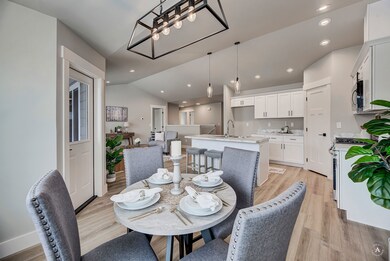 Dining room with vaulted ceiling, light wood-style floors, and recessed lighting