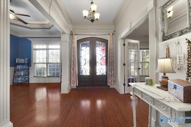 From the elegant crown moulding to the decorative columns to the wood floors, this foyer WOWS floor to ceiling! Dining room to the right and living room to the left upon entry.