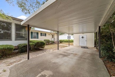 View of patio featuring a carport and a storage shed