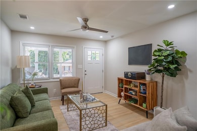 Living room featuring a ceiling fan, light wood-style floors, and recessed lighting