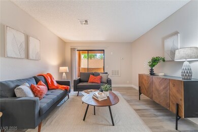 Living area with a textured ceiling, baseboards, v
