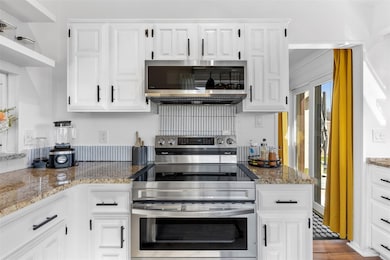Kitchen featuring white cabinetry, appliances with