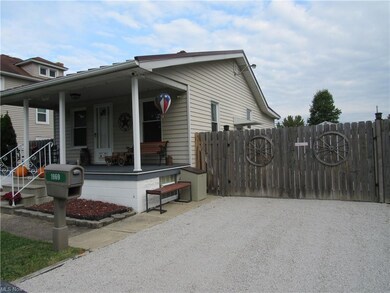 Side of home. Wood privacy fence. Gravel driveway.