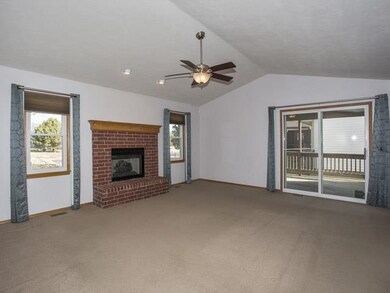 Vaulted living room with fireplace w/ open plan.