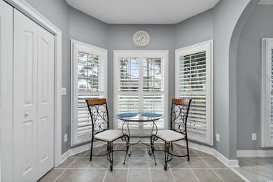 Tiled dining area featuring arched walkways and baseboards