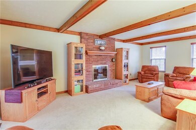 What a fantastic family room!   The floor to ceiling raised brick hearth fireplace features a custom door and rich wood mantel.  The beamed ceiling and crown molding beautifully complements the neutral decor.  Top of the line plush neutral carpet was