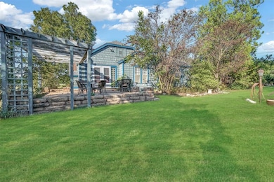 View of grassy yard with a patio pergola