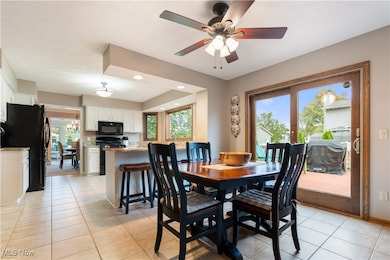 Dining area featuring light tile patterned floors, healthy amount of natural light, recessed lighting, and a chandelier