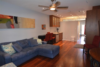 Living area with a ceiling fan, visible vents, ba