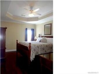 Spacious master bedroom with hardwood flooring VIE