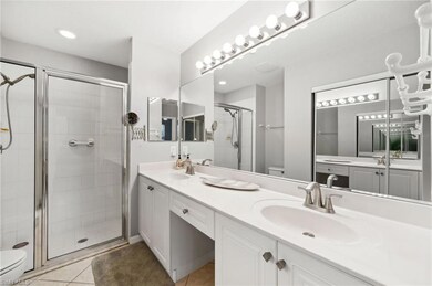 Bathroom with double vanity, tile patterned floors, a shower with shower door, and toilet