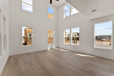 Unfurnished living room featuring light wood-style flooring and a towering ceiling