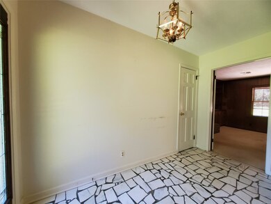 Foyer with cracked tile floor, chandelier and coat