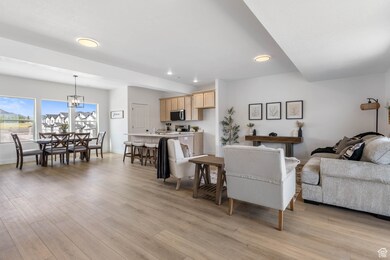 Living area with light wood-style floors, recessed lighting, and a chandelier