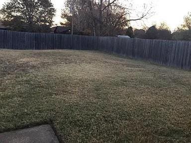 Yard at dusk with a fenced backyard