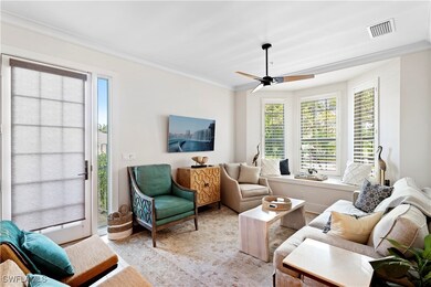 Living room with ceiling fan, crown molding, and l