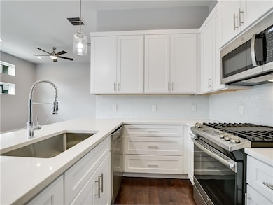 Kitchen with a ceiling fan, a sink, decorative ba