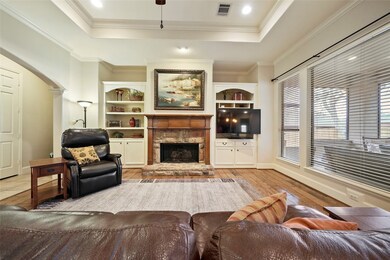 Gas fireplace, built-ins and tray ceiling accent the living area.