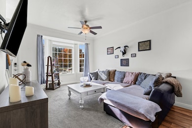 Living room featuring crown molding, a textured ceiling, and ceiling fan