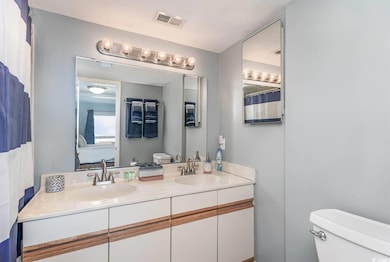 Ensuite bathroom featuring ensuite bath, visible vents, a sink, and toilet