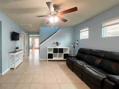 Living area with a ceiling fan, light tile patter