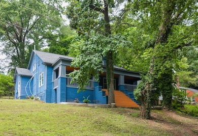 View of front facade featuring a front lawn, covered porch, and a shingled roof