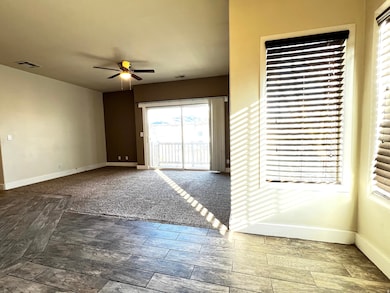 Empty room with ceiling fan and dark wood finished floors