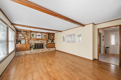 Family room or Den with a brick gas log fireplace and hearth and built in cabinets