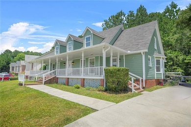 View of front of house with covered porch, a front yard, and roof with shingles
