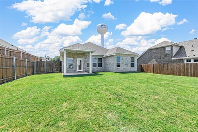 Rear view of property with a lawn and a patio