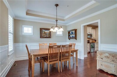 The dining room is perfectly arranged for guests. Like the library - living room, the windows are adorned with plantation shutters & added trey ceiling & crown molding.