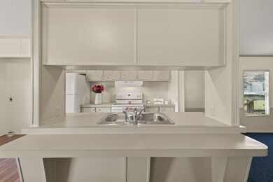 Step inside and be greeted by a bright, cozy kitchen complete with plenty of storage, built-in cabinetry, and a sweet little breakfast nook. Utility space and breakfast knook to the left.  Living room to the right!