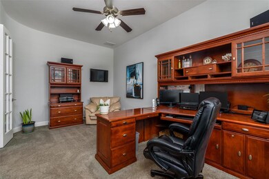 Carpeted office space with ceiling fan and built i