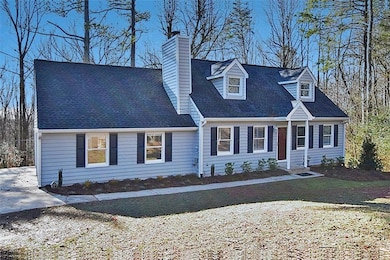 Cape cod house featuring a chimney