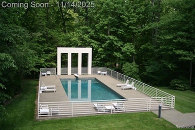 Outdoor pool with a patio area and a lawn