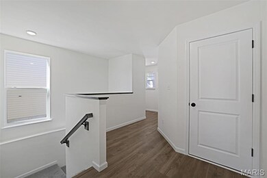 Hall with an upstairs landing and dark wood-type flooring