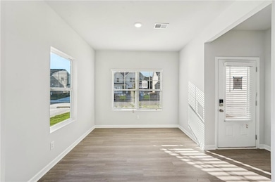 Foyer featuring plenty of natural light, wood finished floors, baseboards, and recessed lighting